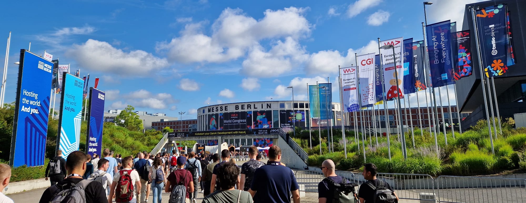 Haupteingang der WeAreDevelopers-Konferenz auf dem Messegelände in Berlin, auf welchen viele Konferenzbesucher zuströmen